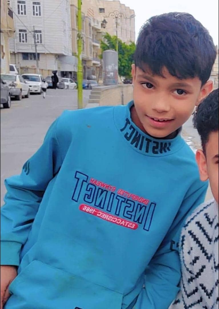 a young boy in a blue sweatshirt with the word i aming on it